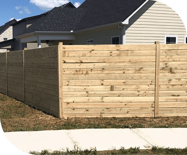 22GettyImages-175604535 Wooden fence in front of suburban houses.