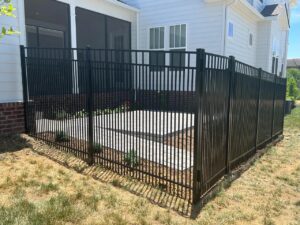 Black metal fence around a patio area.