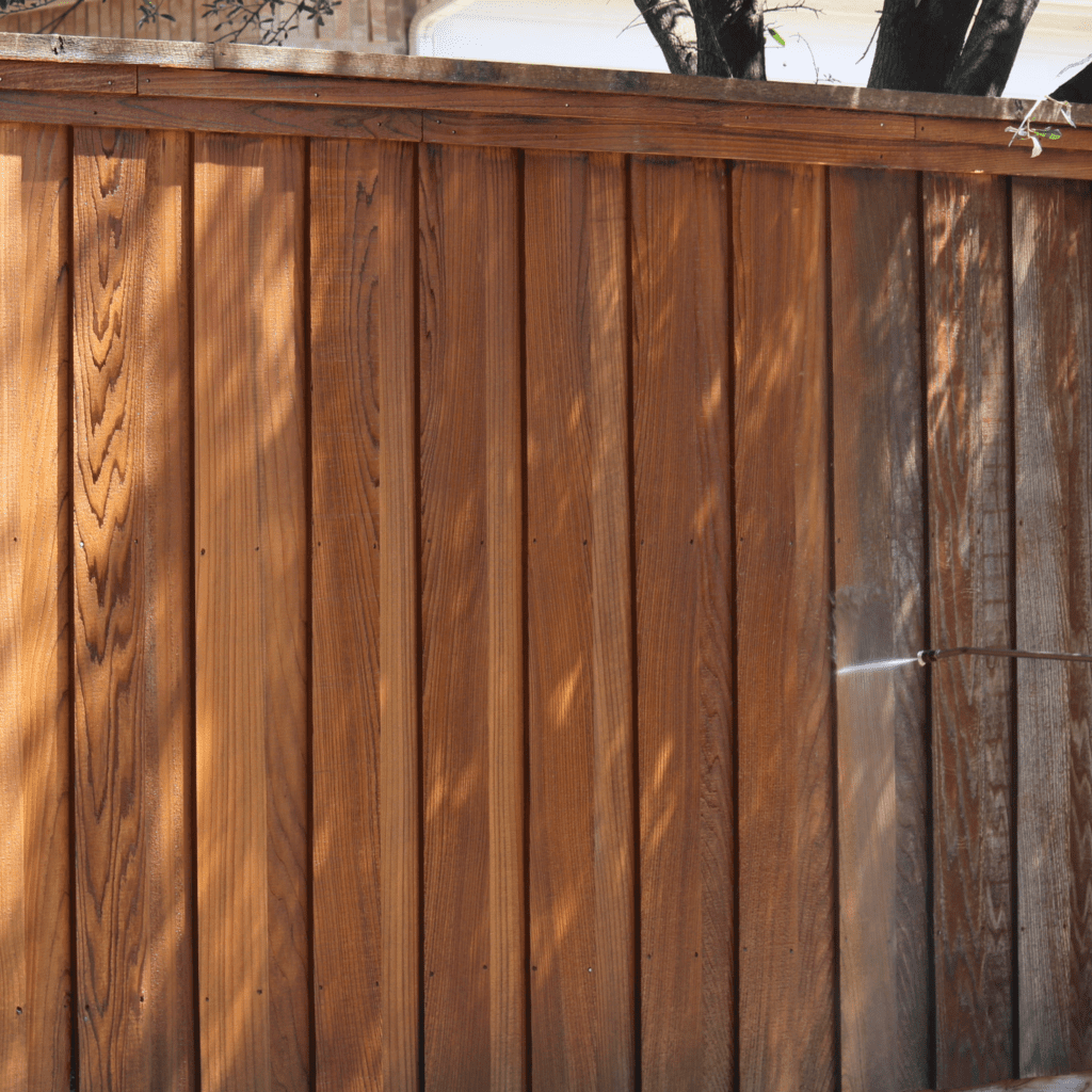 Wooden fence with sunlight and tree shadow.