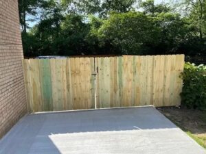 Wooden fence gate on concrete patio.