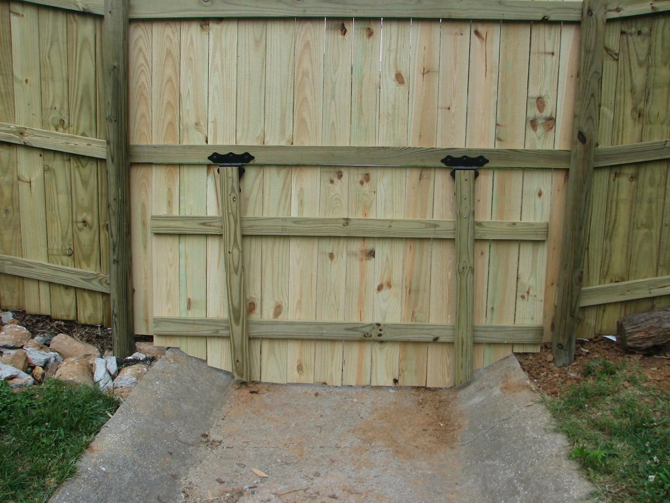 Wooden gate with metal hinges and latch.