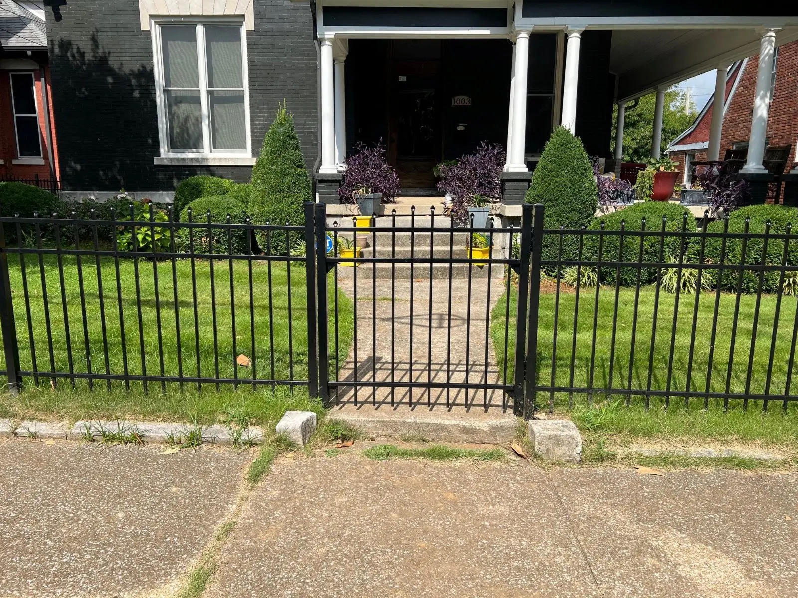 Black iron gate in front of house.